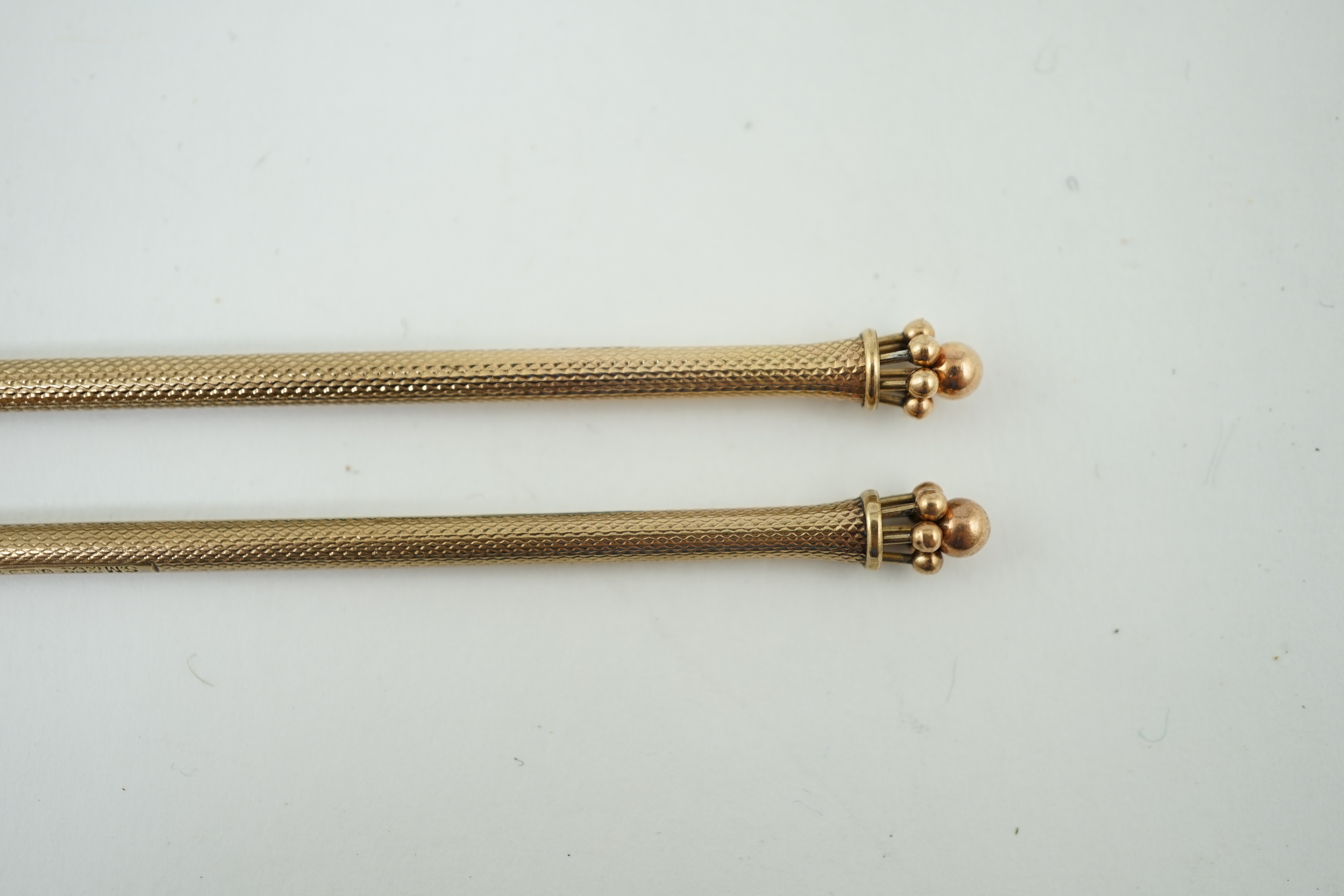 A pair of George V engine turned 9ct gold swizzle sticks, by Sampson Mordan & Co, London, 1934